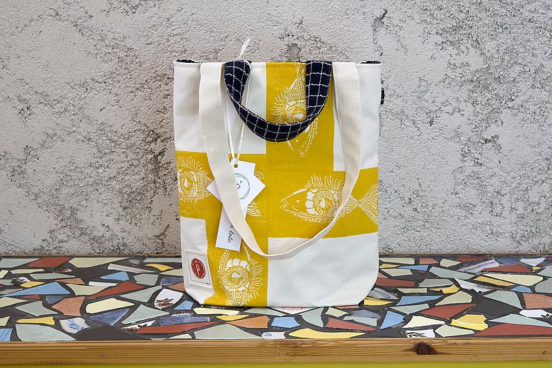Yellow and white checkerboard tote printed with sun and eye motifs, lined in navy grid-print cotton.